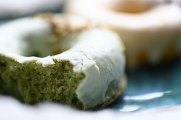 Dessert Polish entitled "colorful tires with icing" - (Close-up) bitten cookies, inside the cake of green spinach and orange carrot,  sprinkled with crushed nuts