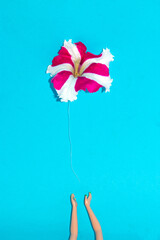 hands that dropped a flower to fly away like a balloon, creative minimal concept, party background, flower balloon