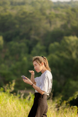 cute girl standing and playing with beautiful nature with clear sky on vacation They stood and took pictures happily.