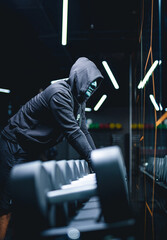 Fototapeta na wymiar Mystery man posing with hoodie on a black background. Strong fit healthy man in dark hoodie.