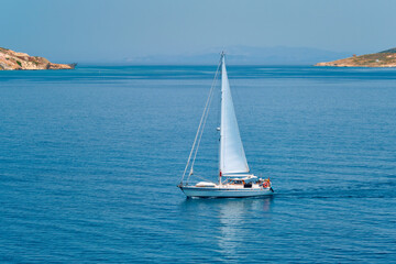 Obraz premium Yacht boat in blue waters of Aegean sea near Milos island , Greece