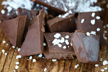 Black chocolate with salt on a wooden surface.