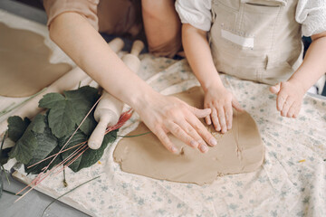 Portrait of mother and little girl shaping clay together