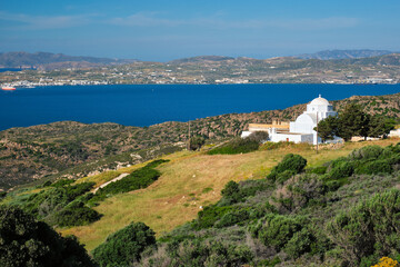 Naklejka na ściany i meble Scenic view of Milos island, Aegean sea and Greek Orthodox traditional whitewashed church. Milos island, Greece
