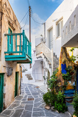 Fototapeta na wymiar Picturesque narrow street with traditional whitewashed houses of Naousa town in famous tourist attraction Paros island, Greece