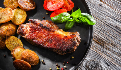 Pan-fried beef steak with fried potatoes and cherry tomatoes