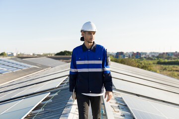 Portrait of Asian engineer on background field of photovoltaic solar panels solar cells on roof top...