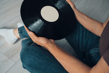 Woman  holding a vinyl record . side view