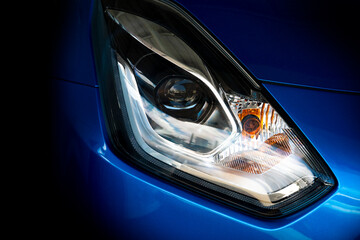 Obraz na płótnie Canvas Abstract dark tone of headlights of blue car is aggressive and gorgeous.