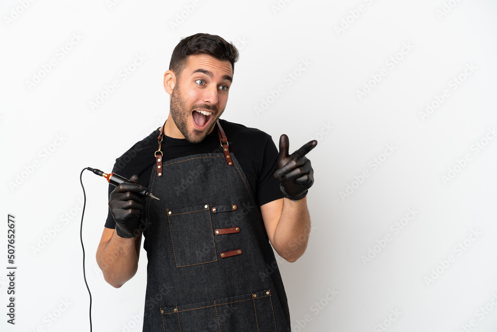 Wall mural Tattoo artist man isolated on white background pointing finger to the side and presenting a product