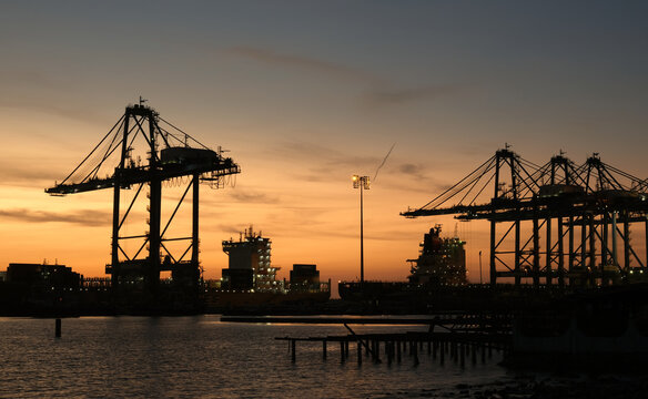 A picture of sunset view silhoutte and long exposure port terminal with ship insight