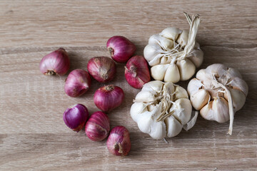 Fresh garlic and onion on wooden table - closeup