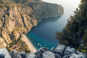 Naklejka premium Beautiful evening seascape of sea. Sandy beach of the blue lagoon landscape. Panoramic view. Butterfly Valley is a valley in Fethiye district, Oludeniz, Turkey. View from the top of the cliff