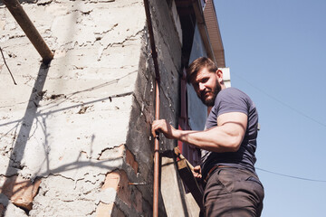 
Strong man running on a ladder
Altitude work on fixing at the height of the cable. Man on the steps. Conducting the Internet on top of the building.