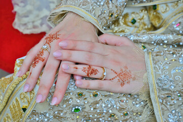 A Moroccan bride puts an Arab henna on her hands. with wedding ring