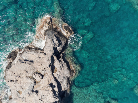 Aerial top view of sea waves hitting rocks on the beach with turquoise sea water. Sea waves on the wild rocky coast. Seascape. Travel concept. Aegean Sea, Turkey. Postcard view. Drone shot © svetlichniy_igor