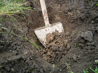 Eine Schaufel im Erdreich. Gartenarbeit, Natur, Nahaufnahme.