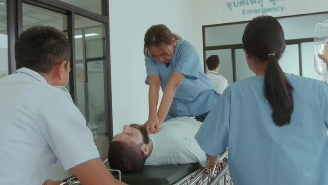 Group of rescue emergency team transporting patient from Emergency car  through Hospital Corridors. cardio pulmonary resuscitation on an unconscious patient .
