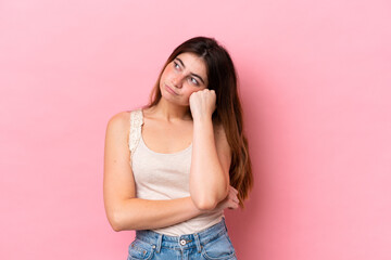 Young caucasian woman isolated on pink background with tired and bored expression