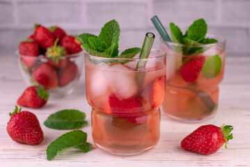 Strawberry mojito with ice. Summer refreshing drink on a white background.
