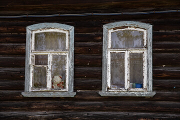 Obraz na płótnie Canvas Fragment of a wooden wall of a traditional Russian house with two Windows