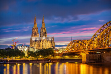 View of the Hohenzollern Bridge over the Rhine River and the iconic Cathedral of Cologne - UNESCO World Heritage Site since 1996