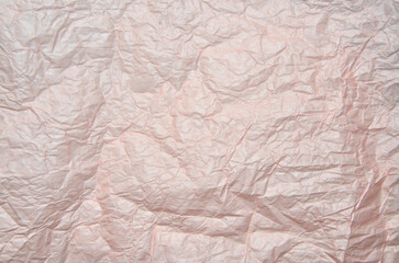 Crumpled pale pink wrapping paper texture background. Full frame of  creased packaging paper texture - abstract backdrop. Recycling concept or element of creative design
