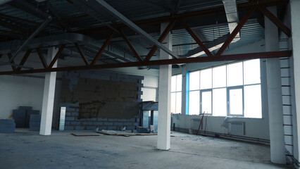 Repair work in empty room with large windows. Stock footage. Renovation in new empty room for company with steel beams and large Windows. White is placed under offices or warehouses