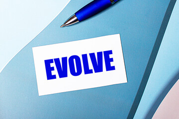White blank card with EVOLVE text and blue pen on blue, cyan and pink background.