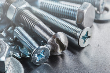 set of different nuts, bolts, screws, washers and drill bits,thread tap and mill cutters on steel plate background. Locksmithing deal.