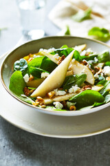 Pear and Spinach Salad with Walnuts and Feta. Close-up