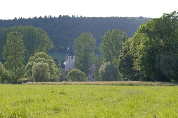 View over the meadows to the small village of Hochhausen with a church in the Taubertal, Germany