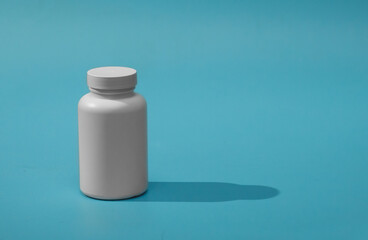 jar of pills isolated on blue background