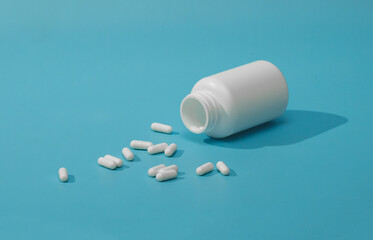 jar of pills isolated on blue background