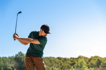 Young man playing golf in summer. Lifestyle game. Healthy and sporty outdoors. Concentration skills...