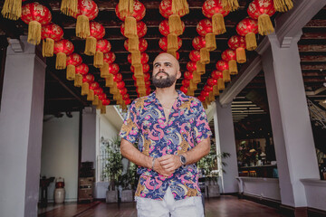 Young man with a backpack on the background of an asian temple