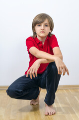 Portrait of cute kid sitting and putting hands on knee