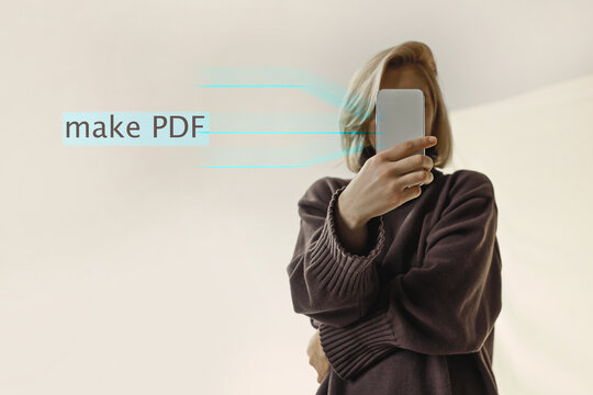 Portrait of a beautiful blonde woman in a brown sweater covering her face with a smartphone, beige background, day