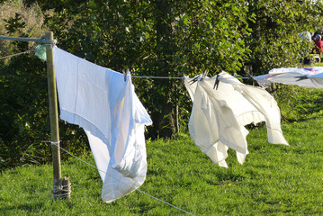 Séchage de la lessive  au vent en plein air , suspendue sur une  corde à linge avec des épingles à linge .
