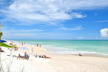 Tourists and locals relaxing on a beautiful, calm beach day in Vero Beach, Florida