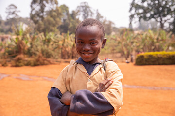 Smiling happy little african schoolchild with Down syndrome alone at schoolyard
