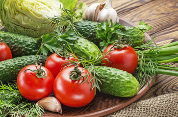 Fresh organic vegetables on a wooden table tomatoes, onions, cucumbers.