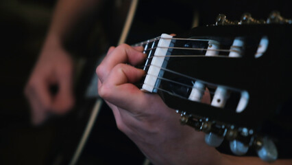 Concept of music and art. Concept. Close-up of man's hands playing on black acoustic guitar