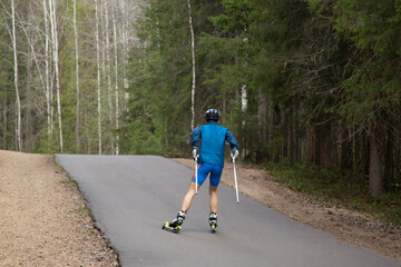 Man ride roller skis in the autumn Park.