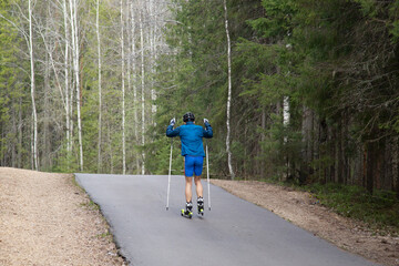 Man ride roller skis in the autumn Park.