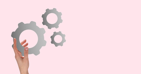 Banner with woman hand holding gear on pink background. Strategy, process organization, business idea concept. Mechanism functioning. Unity and connection symbol. Copy space. High quality photo