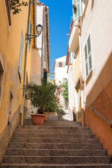 Old narrow authentic street of the city of Villefranche-sur-Mer in the French Riviera resort. Journey along the Cote d'Azur.