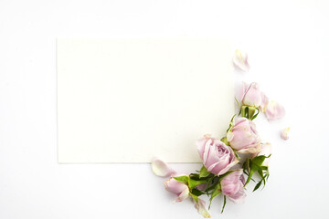 Fototapeta premium Framework from roses and petals on white background. Flat lay.