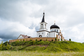 Panorama of the church church against the background of a cloudy sky, an Orthodox monastery stands on a mountain, an old Russian fortress, a Christian monastery.