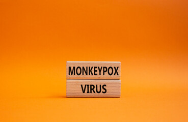 Monkeypox virus symbol. Concept word Monkeypox virus on wooden blocks. Beautiful orange background. Medicine and Monkeypox virus concept. Copy space